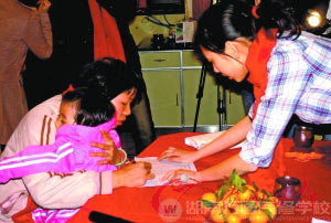 农秀梅抱着孩子签名领取200元路费